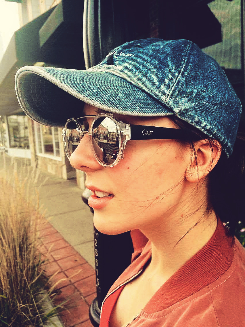 blue jeans ball cap, round sunglasses and red shirt collar , pretty girl in Medicine Hat Alberta